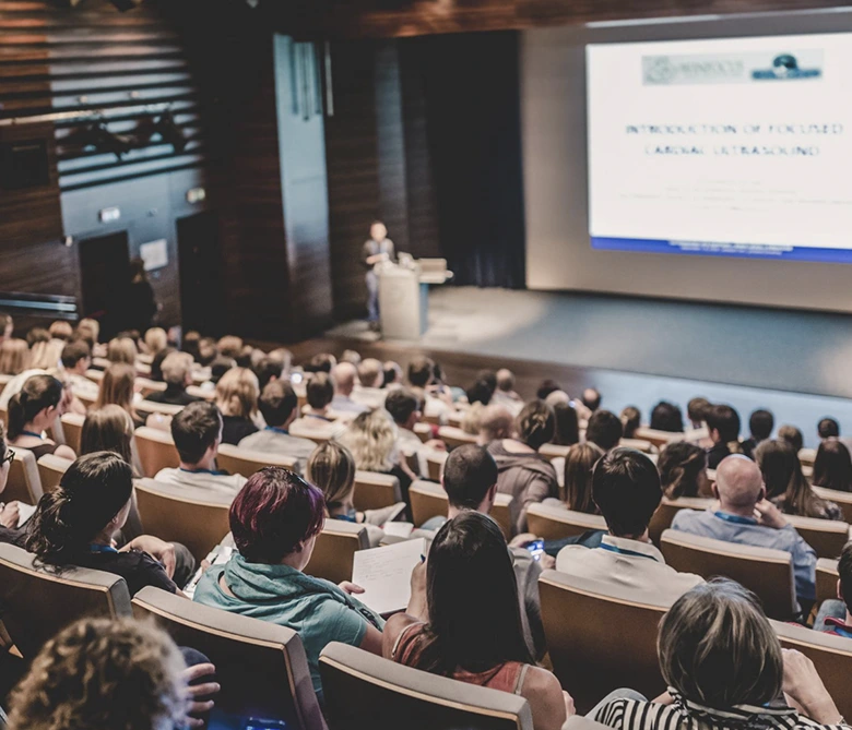 grupo de personas sentadas escuchando conferencia